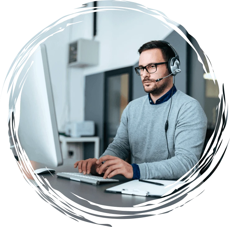 a stock photo of a male customer service representative wearing a headset and working at a computer