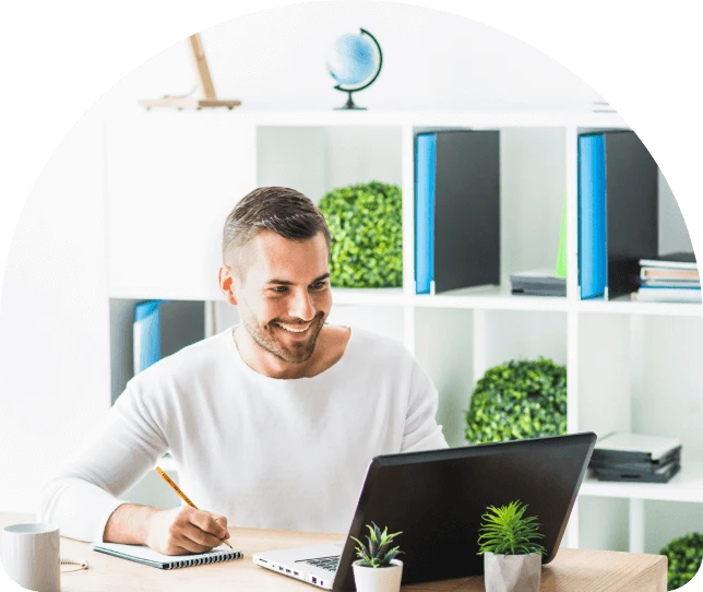 person working on a laptop and taking some notes